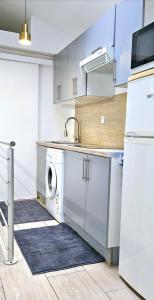 a kitchen with a sink and a washing machine at Villa Hélène in Créteil