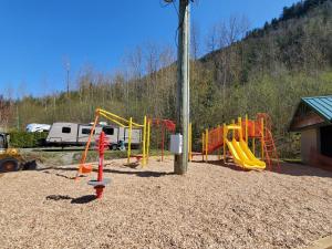 a playground with a yellow and orange play equipment at Camperland Bridal Falls RV Resort & Cabins in Rosedale