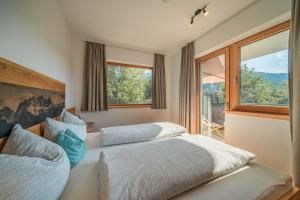 1 dormitorio con 2 camas y ventana grande en Appartement Andrea Cäciel en Brixen im Thale