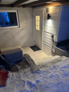 una puerta delantera de una casa con nieve alrededor en Kirkegårdsveie 62, 