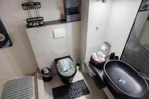 a bathroom with a black toilet and a sink at Duplex lux - Thoria in Bucharest +56 photos