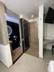 La salle de bains est pourvue d'une douche avec une porte en verre. dans l'établissement Hotel Plaza Norte Cali, à Cali
