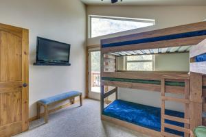 a bedroom with two bunk beds and a tv at Angel Fire Cabin with Deck 3 Mi to Ski Lifts! in Angel Fire