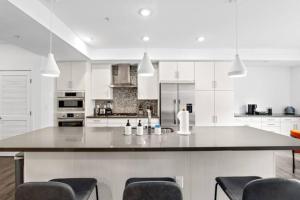 una cocina blanca con una isla grande con sillas en Luxurious 2-Bedroom 2-Bath Unit with Marina Views en Los Ángeles