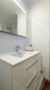 een witte badkamer met een wastafel en een spiegel bij Residential Golf Park - Casa Prezi in San Miguel de Abona