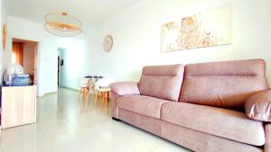 een woonkamer met een bruine bank en een tafel bij Residential Golf Park - Casa Prezi in San Miguel de Abona