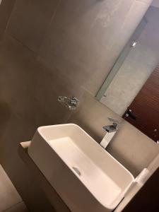 W łazience znajduje się biała umywalka i lustro. w obiekcie Zayn villa w mieście Mount Lavinia
