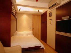 1 dormitorio con 1 cama y TV de pantalla plana en Mingle At The Eden, en Hong Kong