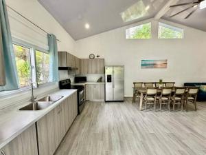 a kitchen with a sink and a table with chairs at Villa Cielo, Casa de playa in Jacó