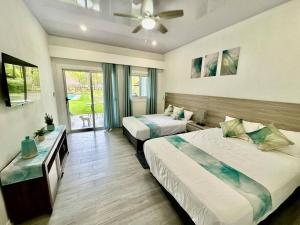 a hotel room with two beds and a window at Villa Cielo, Casa de playa in Jacó +20 photos
