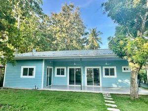 a blue house with a yard in front of it at Villa Cielo, Casa de playa in Jacó