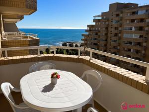 - une table et des chaises blanches sur un balcon donnant sur l'océan dans l'établissement Tu Sueño en el Mediterráneo, à Oropesa del Mar