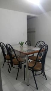 alojamiento cerca centro histórico Popayán. في بوبايان: طاولة وكراسي خشبية عليها نبات
