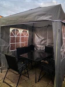 une tente avec une table et des chaises. dans l'établissement Students Contractors Professionals, à Leicester