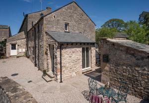 an external view of a stone building with a table and chairs at Stunning - 2 Bedroom - 2 Bathroom home - Nr Kirkby Lonsdale in Carnforth
