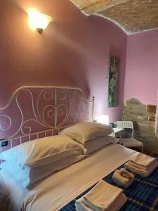 1 dormitorio con 1 cama grande y pared morada en B&B Happiness in the Country, en Brescello