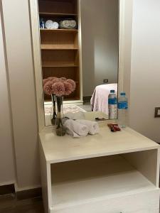 a dressing table with a mirror and flowers on it at New furnished apartment in Cairo