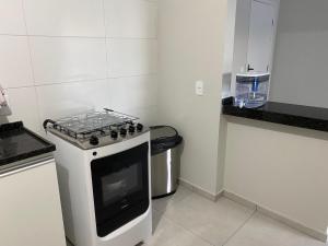 una pequeña cocina con fogones y cubo de basura en Apartamento próximo ao Pão de Açúcar e centro, en Limeira