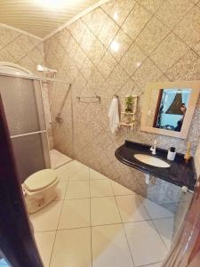 W łazience znajduje się toaleta, umywalka i lustro. w obiekcie Aquiri Hostel w mieście Rio Branco
