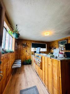 a kitchen with wooden walls and a counter in a room at Deer Lodge in Red River