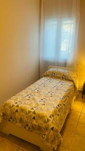 a bed sitting in a room with a window at Appartamento Polpenazze in Polpenazze del Garda