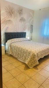 a bedroom with a bed with a bedspread on it at Appartamento Polpenazze in Polpenazze del Garda