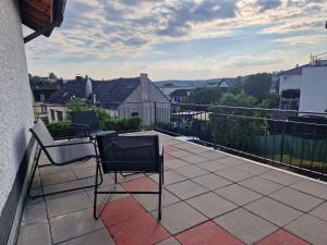 a balcony with two chairs and a view of a city at Stilvolle Wohnung mit Terasse und Garten in Höhr-Grenzhausen