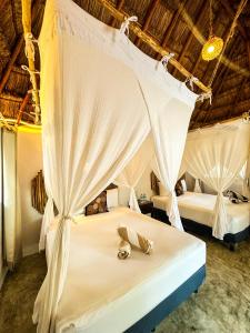 a bedroom with two beds with mosquito nets at Alito Tulum Hotel in Tulum