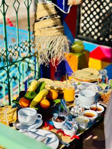 a table topped with a buffet of food and fruit at Riad Eva in Marrakesh