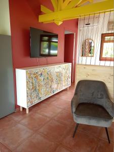 a living room with a tv and a chair at La Mare à Cuja in Sainte-Rose