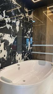 uma banheira na casa de banho com azulejos pretos e brancos em Hotel Calle Real Inn em Aguachica