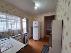 een keuken met een witte koelkast en een wastafel bij Apartamento em São Vicente in São Vicente