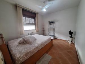 een slaapkamer met een bed en een raam bij Apartamento em São Vicente in São Vicente