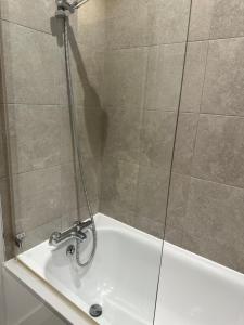 a bathroom with a shower with a bath tub at Stunning Flat with Parking Free near Sutton Station in Cheam