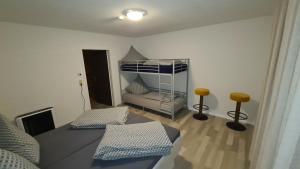 a room with a bunk bed and two stools at Apartament Berghof in Bayerischen Wald in Sankt Englmar