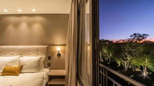 a bedroom with a bed and a large window at CHATEAU DU GOLDEN in Gramado