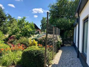 a garden with flowers and a fence at Heerlijk halfvrijstaande woning in Hierden
