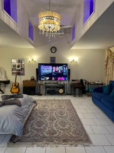 a living room with a tv and a blue couch at Amazing Gantshill Studio Annexe & Free Parking in Redbridge