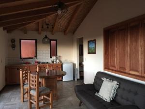 een keuken en een woonkamer met een tafel en een bank bij Brisas de Sol in Pátzcuaro