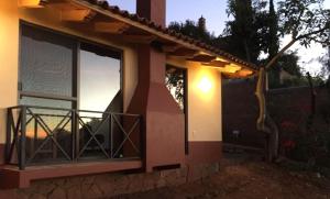 a house with a balcony with a light on it at Brisas de Sol in Pátzcuaro