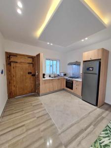 uma grande cozinha com armários de madeira e um frigorífico em Raya em Midoun