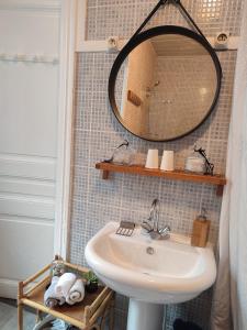 La salle de bains est pourvue d'un lavabo et d'un miroir mural. dans l'établissement Villa Seven Malo, à Dunkerque
