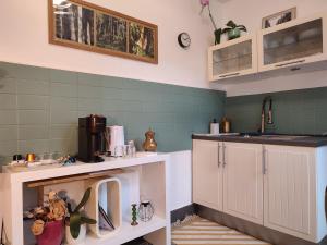 une cuisine avec des placards blancs et du carrelage vert dans l'établissement Villa Seven Malo, à Dunkerque