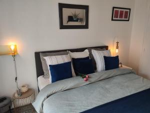 - une chambre dotée d'un grand lit avec des oreillers bleus et blancs dans l'établissement Villa Seven Malo, à Dunkerque