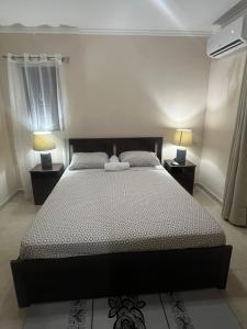 a bedroom with a large bed with two lamps at Stylish Stay Ciudad Juan Bosch in Los Paredones