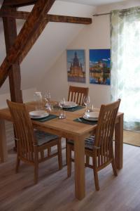 een eettafel met stoelen en een houten tafel en een stoeltje bij Apartment Traumzeit mit Balkon in Vorstadtvilla in Dresden