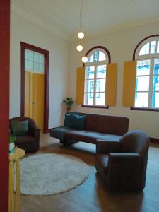 a living room with a couch and two chairs at É Hostel - Guesthouse in Ouro Preto