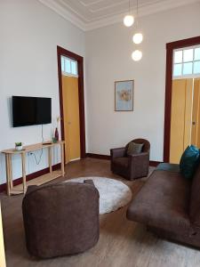ein Wohnzimmer mit 2 Sofas und einem Flachbild-TV in der Unterkunft É Hostel - Guesthouse in Ouro Preto