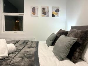 a bedroom with a bed with pillows and a window at Luxury Victorian House Sleeps 6 - 11 Guests JLR, Trades, Relocations & Hs2 Welcome Wheelchair Accessible Home FREE Faster WIFI & PARKING in Coventry