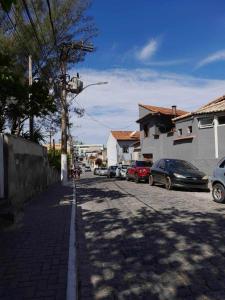 a street with cars parked on the side of the road at Apartamento Saquarema Centro in Saquarema